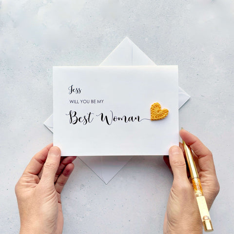 A white card with ‘Will you be my Best Woman’ printed on it. The words ‘Best Woman’ appears larger than the rest of the text and it has a little yellow crochet heart at the end of the word.  The name ‘Jess’ has been printed at the top of the text, making this card a lovely keepsake. 