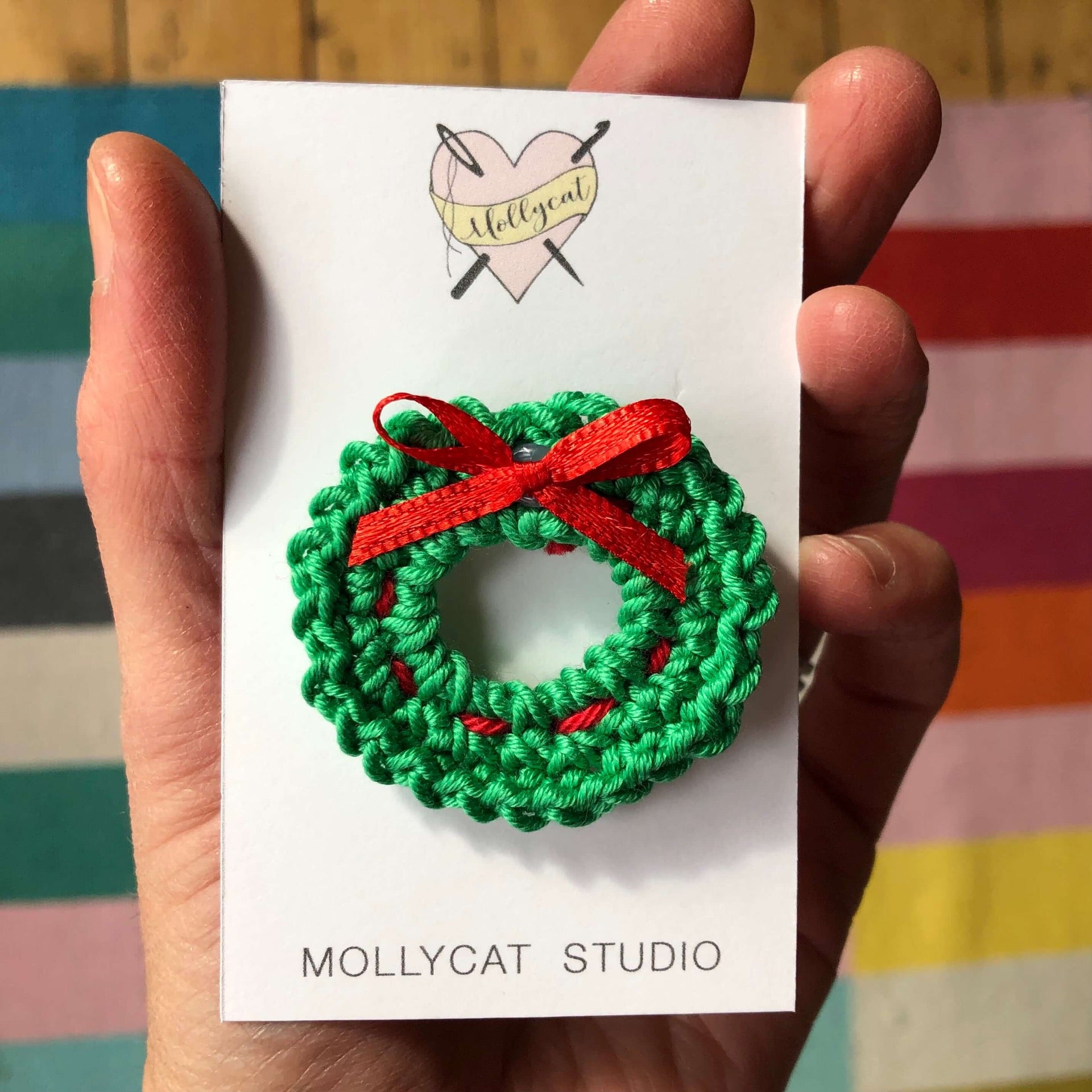 A crochet green and red Christmas wreath , Made by Jules Cooke, Mollycat Studio - a small business based in Liverpool UK